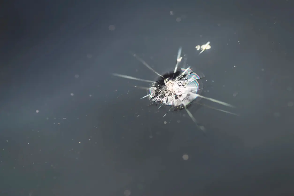 A bullet hole in the glass of a car.