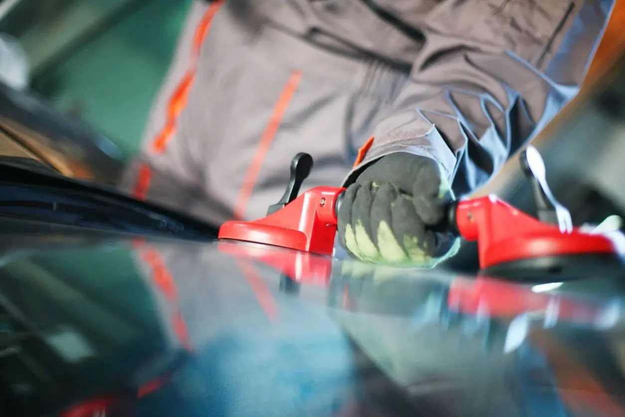 A person holding onto the handle of a red tool.